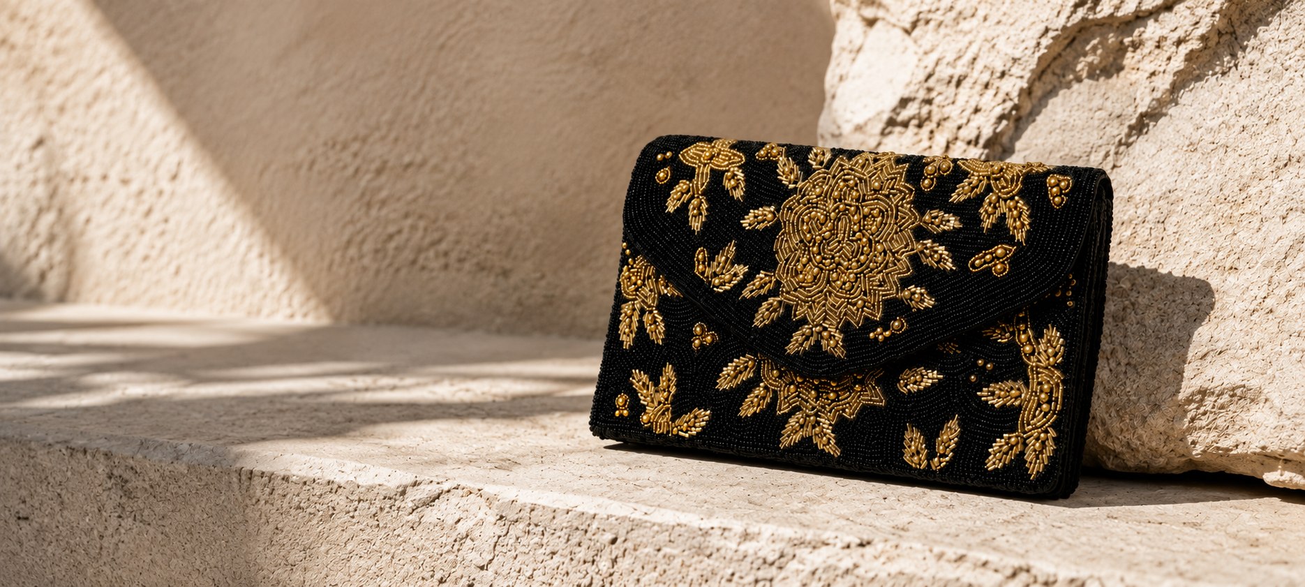 Escena editorial con bolso negro bordado en tonos dorados