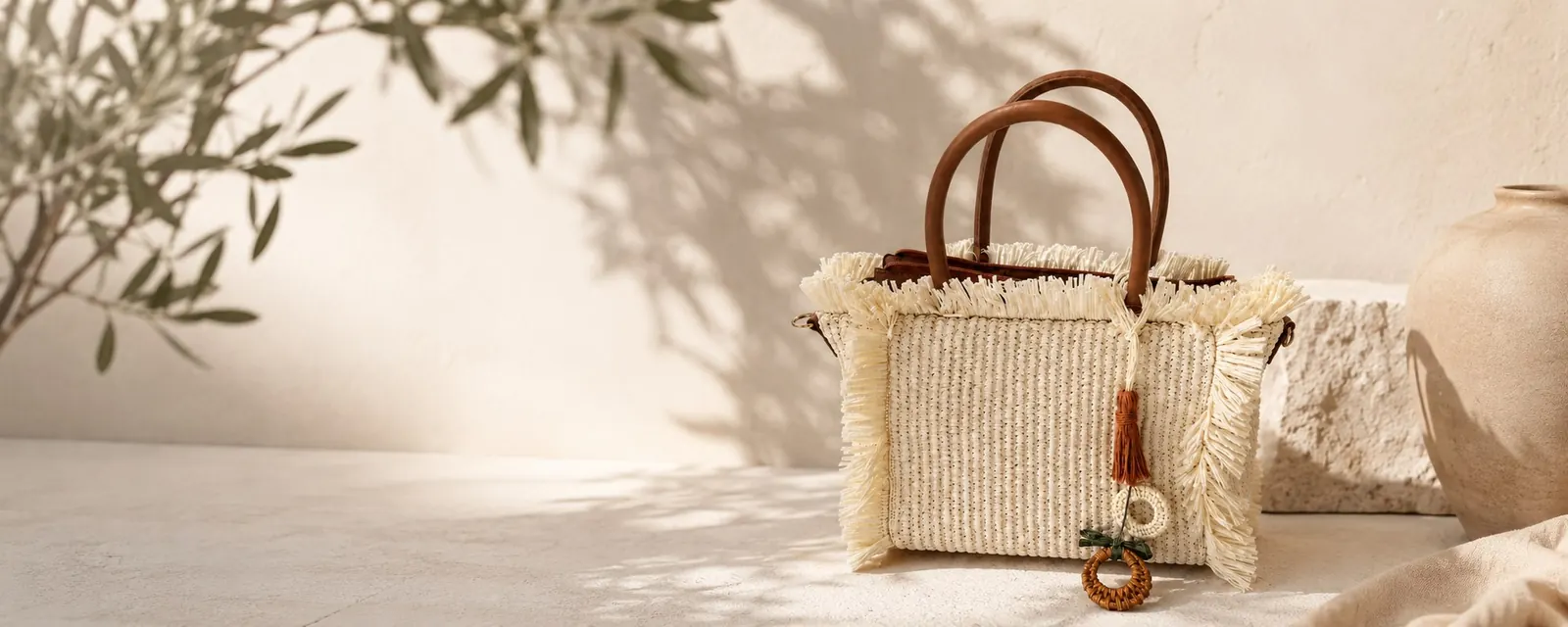 Bolso de rafia Florenti en una escena mediterránea de tonos crema